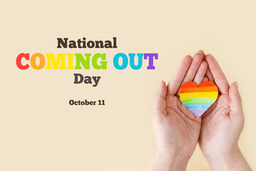 National coming out day. Stop Homophobia. Heart with rainbow LGBT flag in the hands