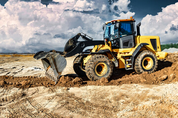 Powerful bulldozer or loader moves the earth at the construction site against the sky. An earthmoving machine is leveling the site. Construction heavy equipment for earthworks.