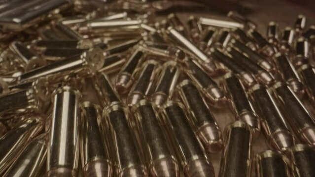 Macro dolly out of old western revolver trigger and revealing a lot of .357 ammunition