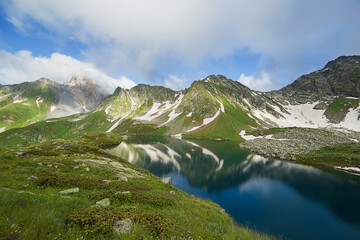 Naklejka na ściany i meble A beautiful mountain lake against the backdrop of a mountain range.