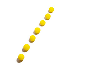 a strip of yellow round candies on a white background