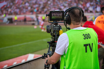TV crew at the pitch. Cameraman at work at the football or soccer game at stadium at night in Belgrade, Serbia 22.05.2022