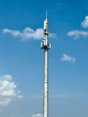 Macro Base Station. 5G radio network telecommunication equipment with radio modules and smart antennas mounted on a metal against cloulds sky background. Telecommunication tower of 4G and 5G cellular.