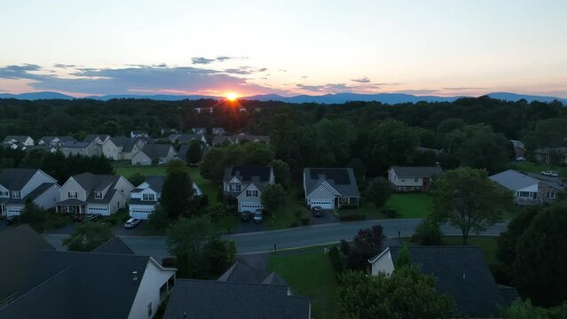 Evening sunset in residential neighborhood in USA. American houses in quiet development. Aerial.