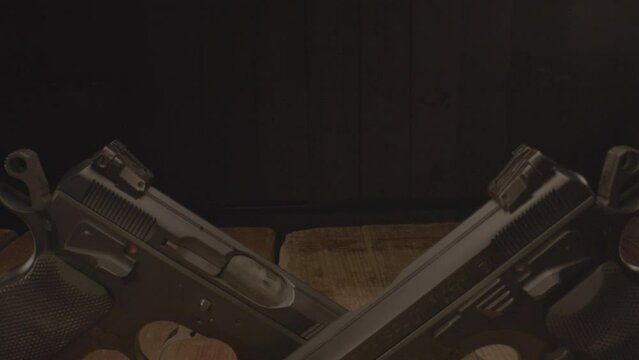 Dolly over two cocked pistols on a wooden surface