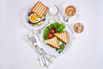 Tasty breakfast - sandwiches with fried eggs and bacon and fresh hot coffee