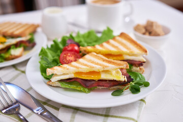 Tasty breakfast - sandwiches with fried eggs and bacon and fresh hot coffee