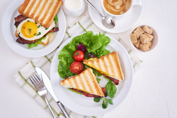 Tasty breakfast - sandwiches with fried eggs and bacon and fresh hot coffee
