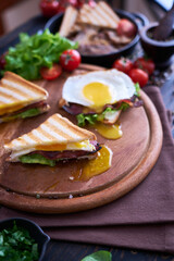 French toasts with fried eggs, cream cheese, salad and bacon
