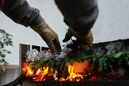 Unrecognizable person grilling calcots on terrace