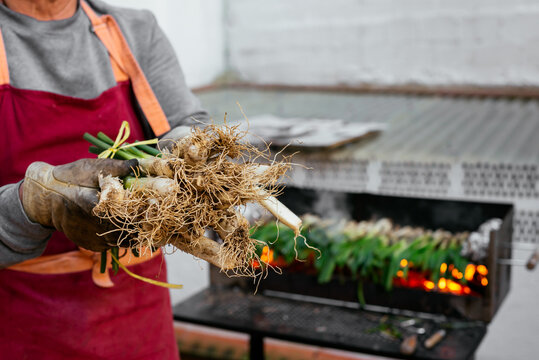 Man with calcots near grill