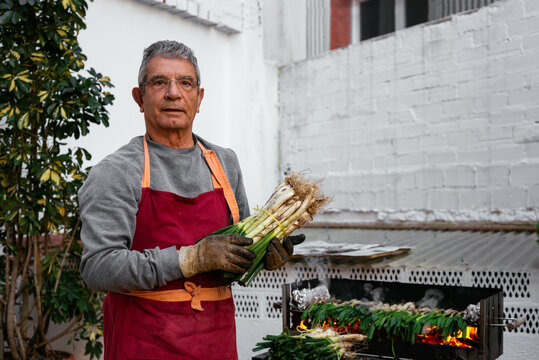 Man with calcots near grill