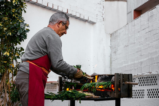 Man grilling calcots on terrace