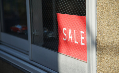 Red sign with the word SALE visible through the window of the building