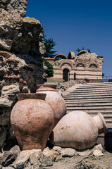An ancient antique clay jar lies among the ruins of a Mediterranean city. T