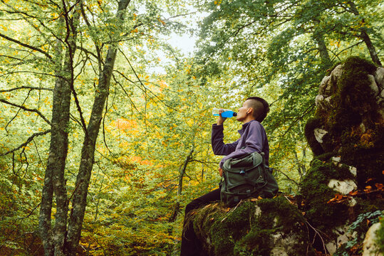 Woman drinking fresh beverage hiking in park