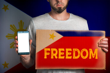 Concept of freedoms and human rights. A man with a cardboard and a phone in his hand. The Flag of...
