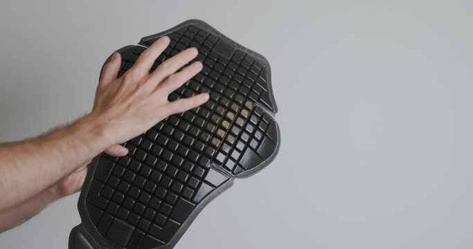 Dismantling the back protection for a motorcycle jacket. Plastic plate with flexible squares.