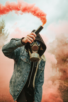 Person holding smoke bomb on street