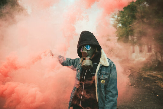 Person holding smoke bomb on street