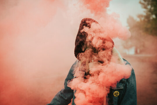 Person holding smoke bomb on street
