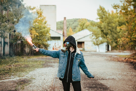 Person holding smoke bomb on street