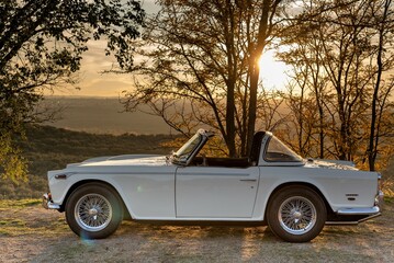 Puesta de sol con coche elegante de color blanco