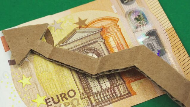 Economy concept. On the euro, a person's hand puts an arrow showing the growth of the economy.
