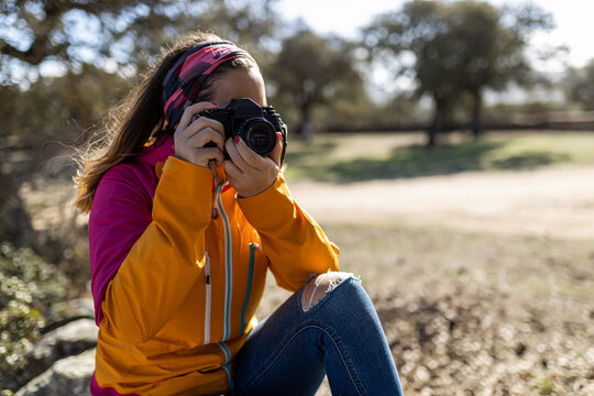Anonymous woman taking picture of nature with professional camera
