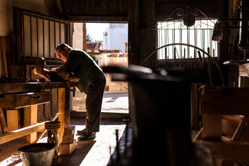 Elderly carpenter working with wood