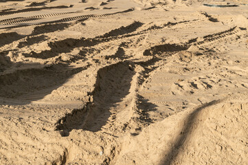 abstract background with traces of construction equipment on the sand