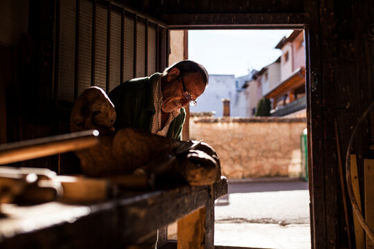 Elderly carpenter working with wood