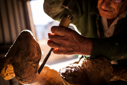 Elderly carpenter working with wood