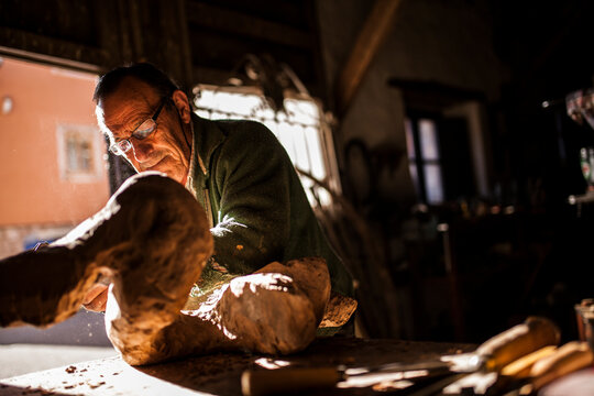 Elderly carpenter working with wood