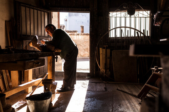Elderly carpenter working with wood