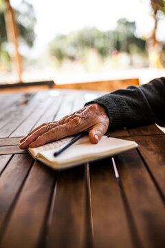 elderly man writing in his notebook