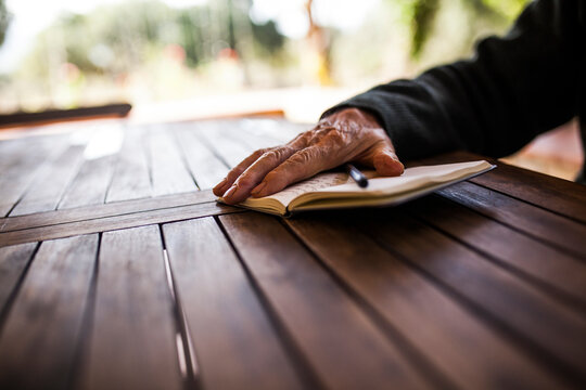 elderly man writing in his notebook