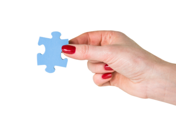 Female hand holding the missing piece of jigsaw puzzle