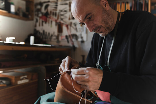 Man sewing textile in atelier