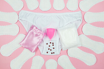 Obraz na płótnie Canvas panties, pads, menstrual cup on a pink background.