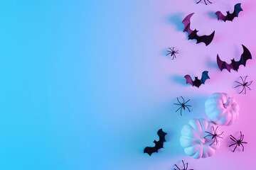 Creative flat lay Halloween background with bats silhouettes and pumpkins painted in vibrant...