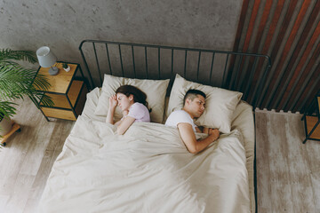 Top view from above young tired sad frustrated couple two family man woman she he 20s wear t-shirt...