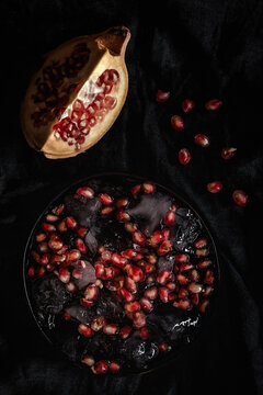 Fresh and red pomegranate on dark background