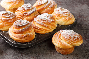 Homemade pastries cruffins, muffin with sugar powder, on dark background, selective focuse close up. Horizontal