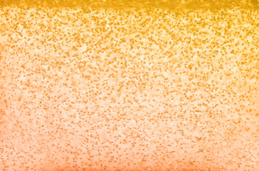 Soda water with bubbles of gas, closeup. Toned in orange