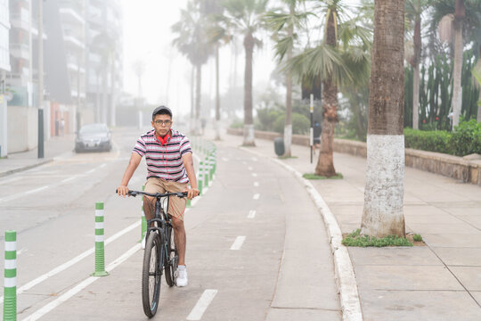Latin man riding bicycle on sidewalk