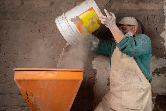 Man poring dry mix into plaster station