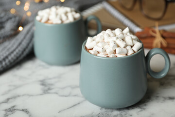 Obraz na płótnie Canvas Delicious hot cocoa drink with marshmallows in cups on white marble table