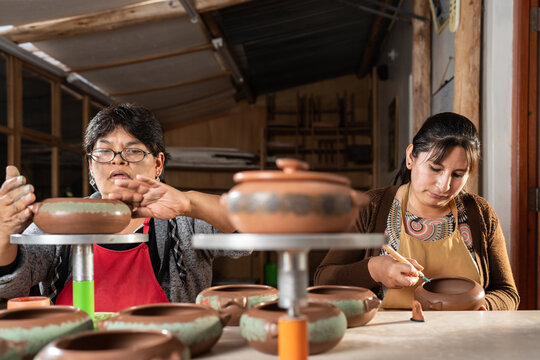 Peruvian women painting ceramic bowls