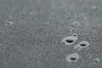 Water drops on grey surface, closeup view